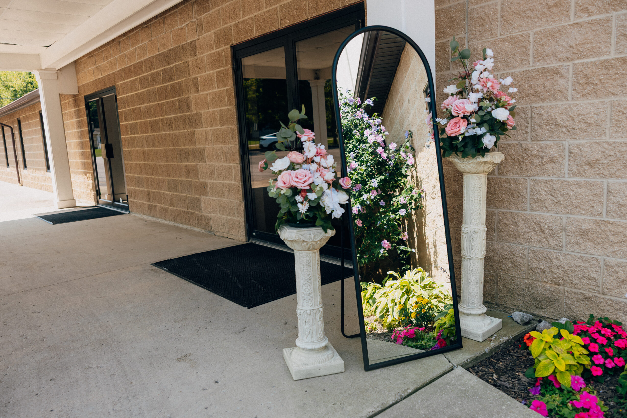 A decorative mirror with flowers outside a church.