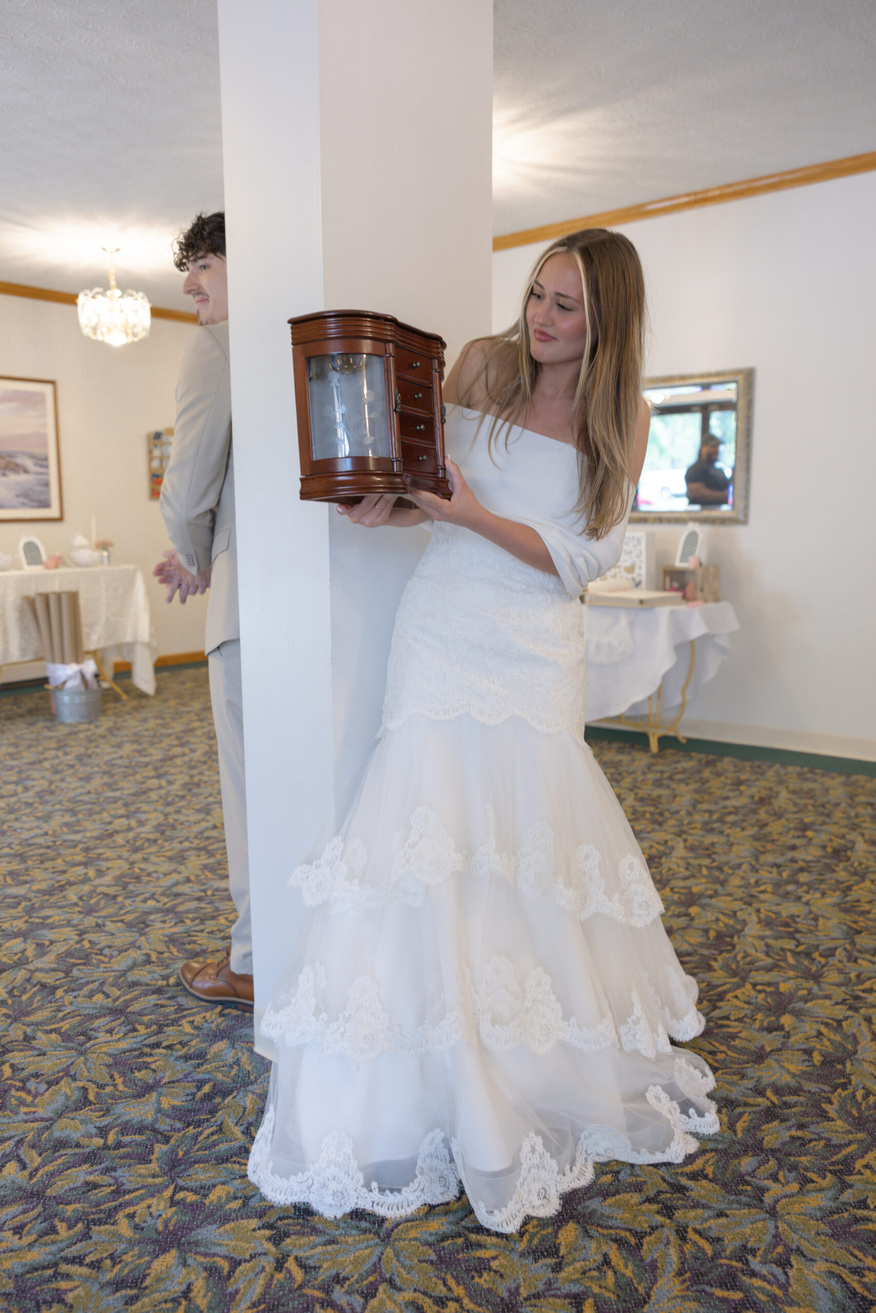 A bride accepting a gift of a jewelry box from her groom.