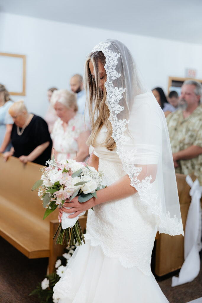 A bride praying at the end of the alter.
