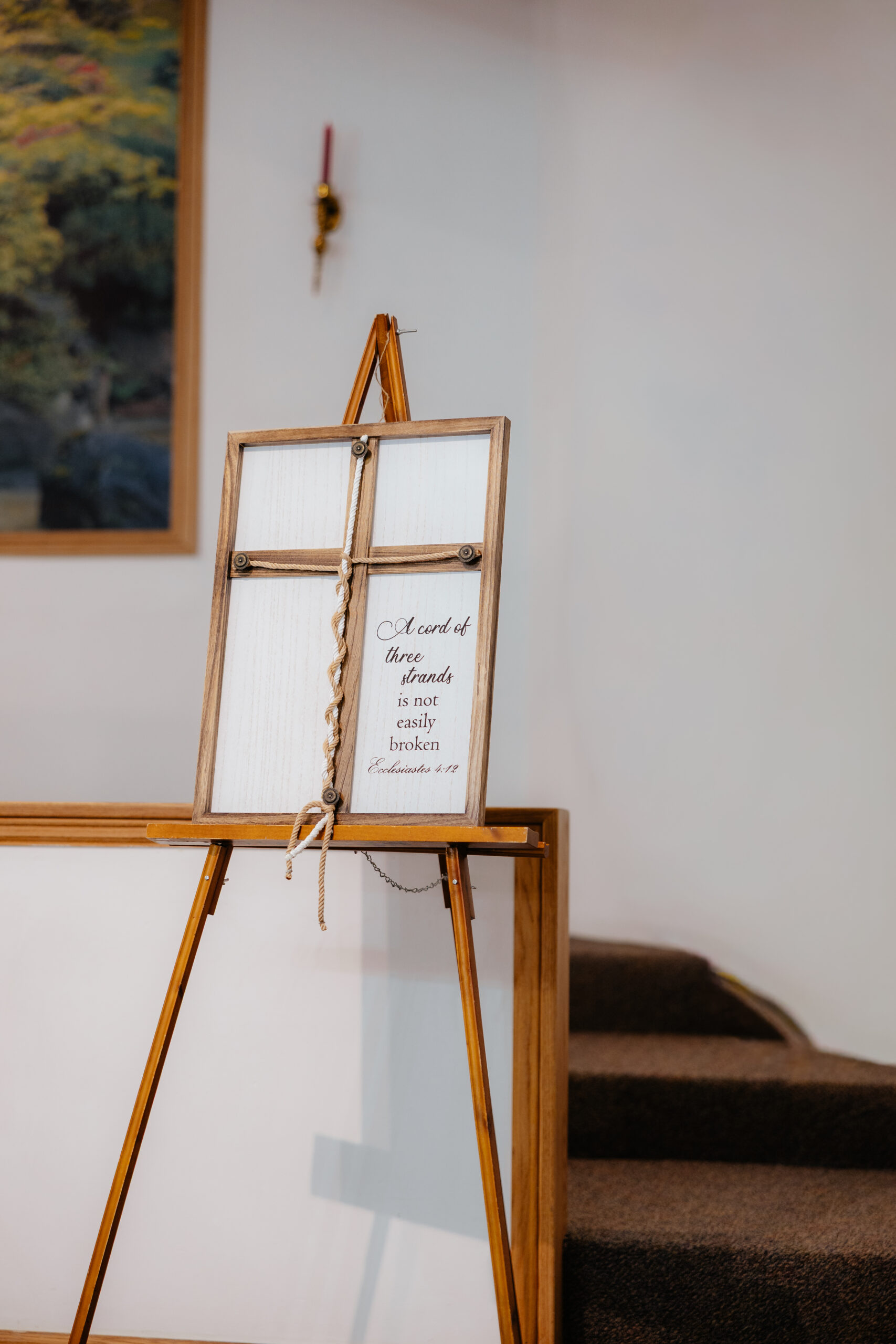 A cross with a rope braided as decor at a wedding.