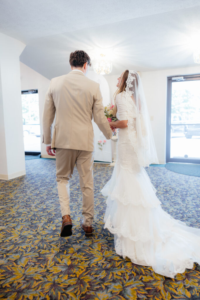 A bride and groom walking away together after their ceremony.