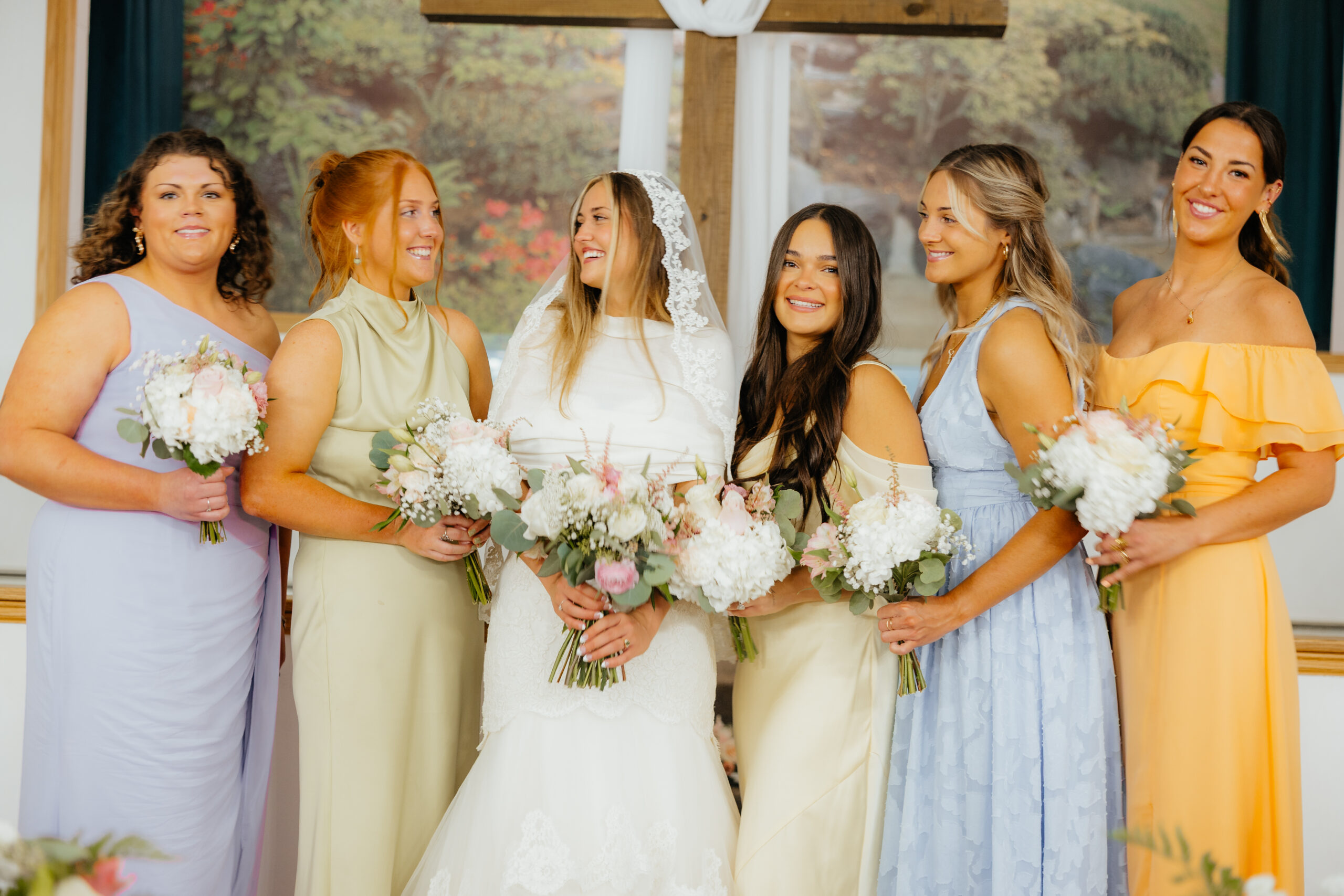 A bride and her bridesmaids posing with their bouquets.