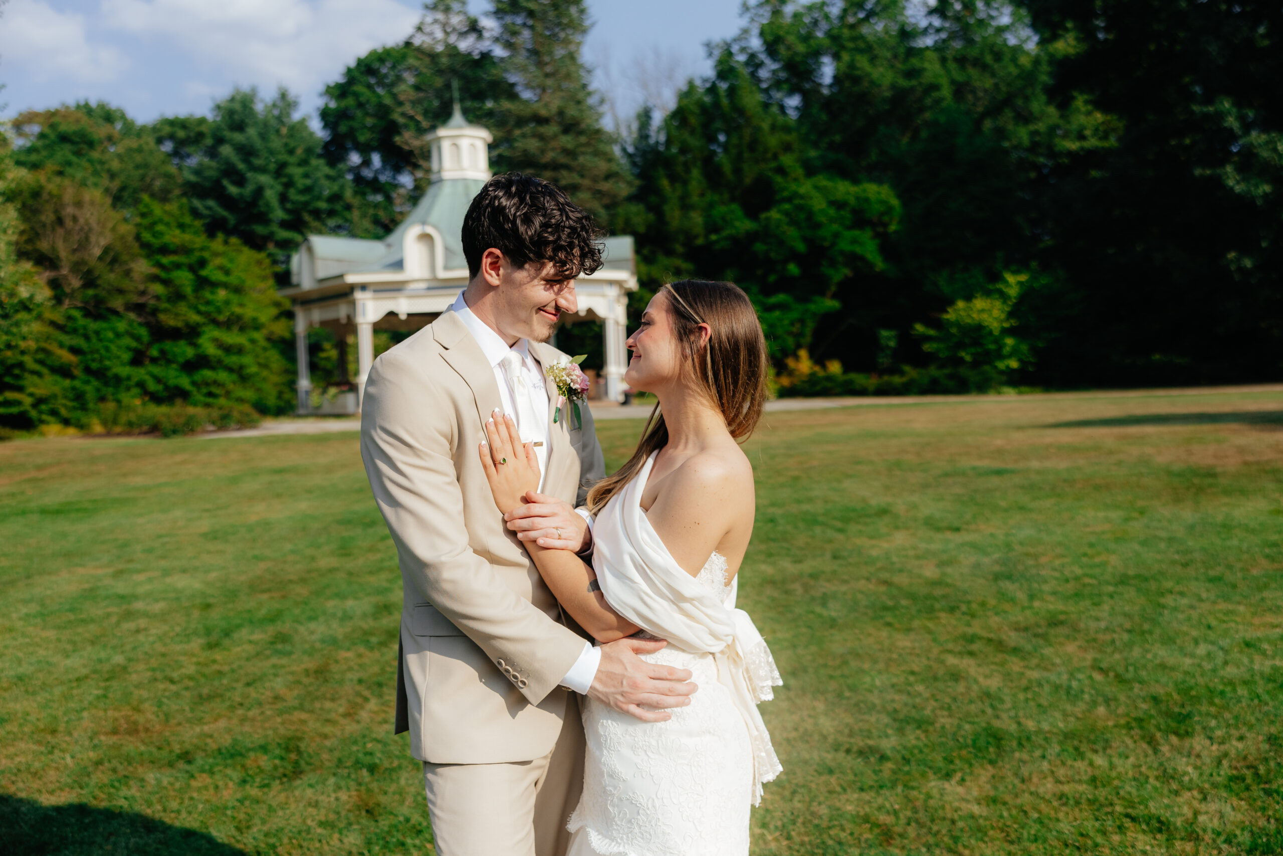 A bride and groom posed together in a park.