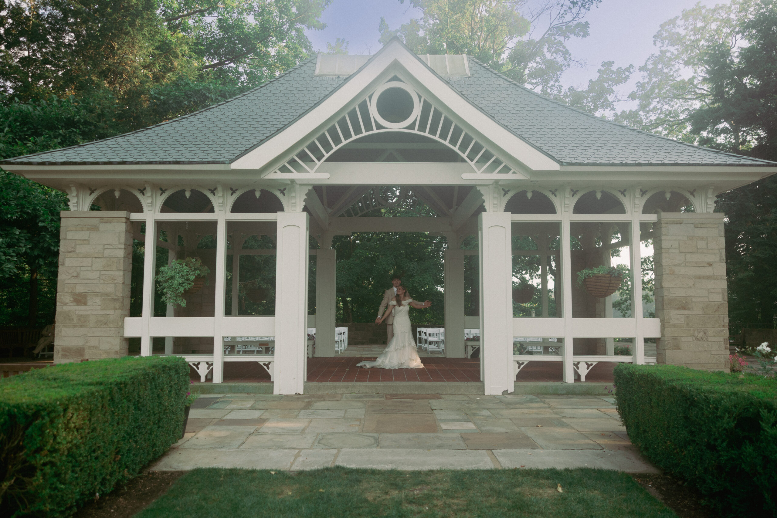 A bride and groom under a gazebo.