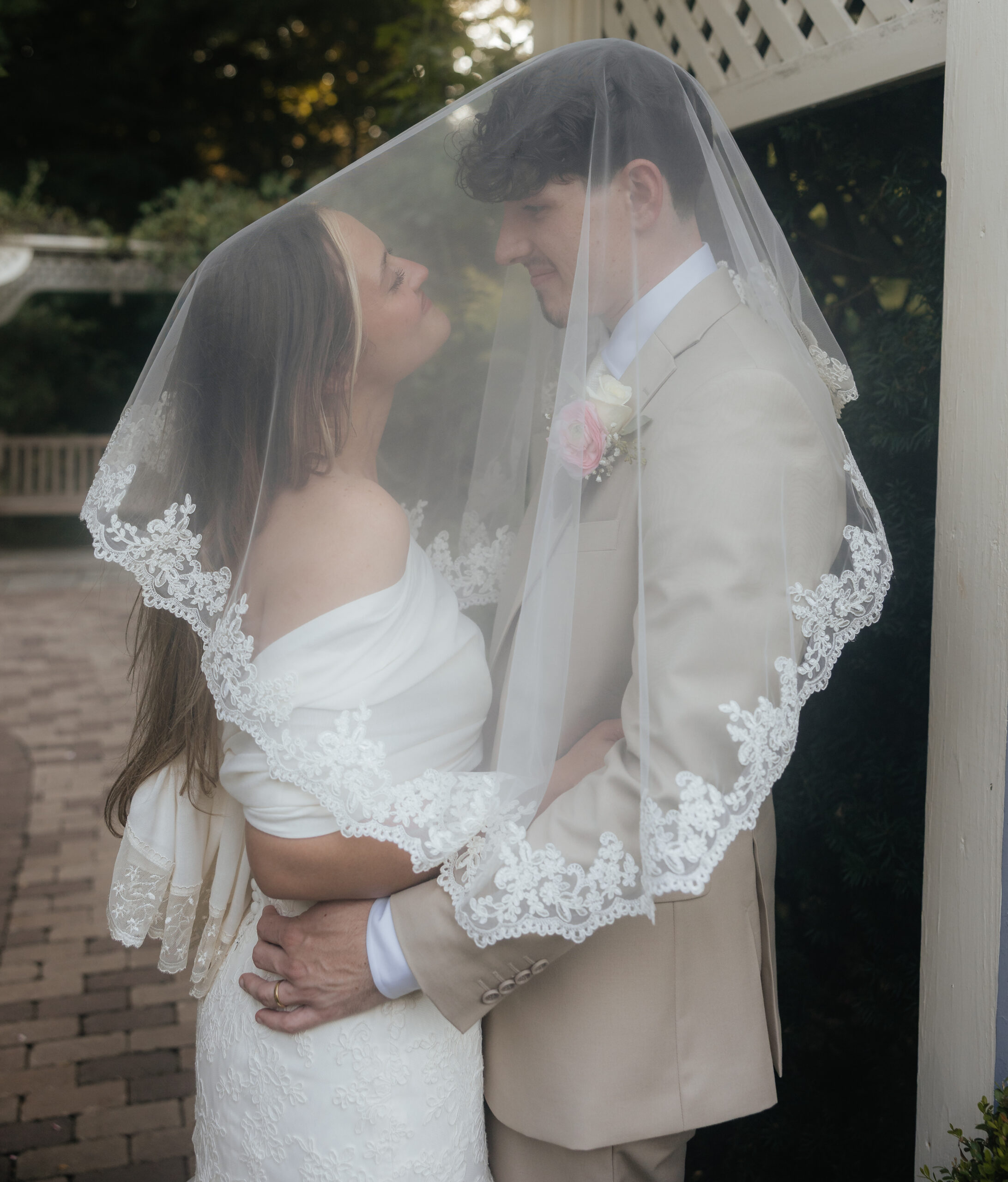A bride and groom under a veil.